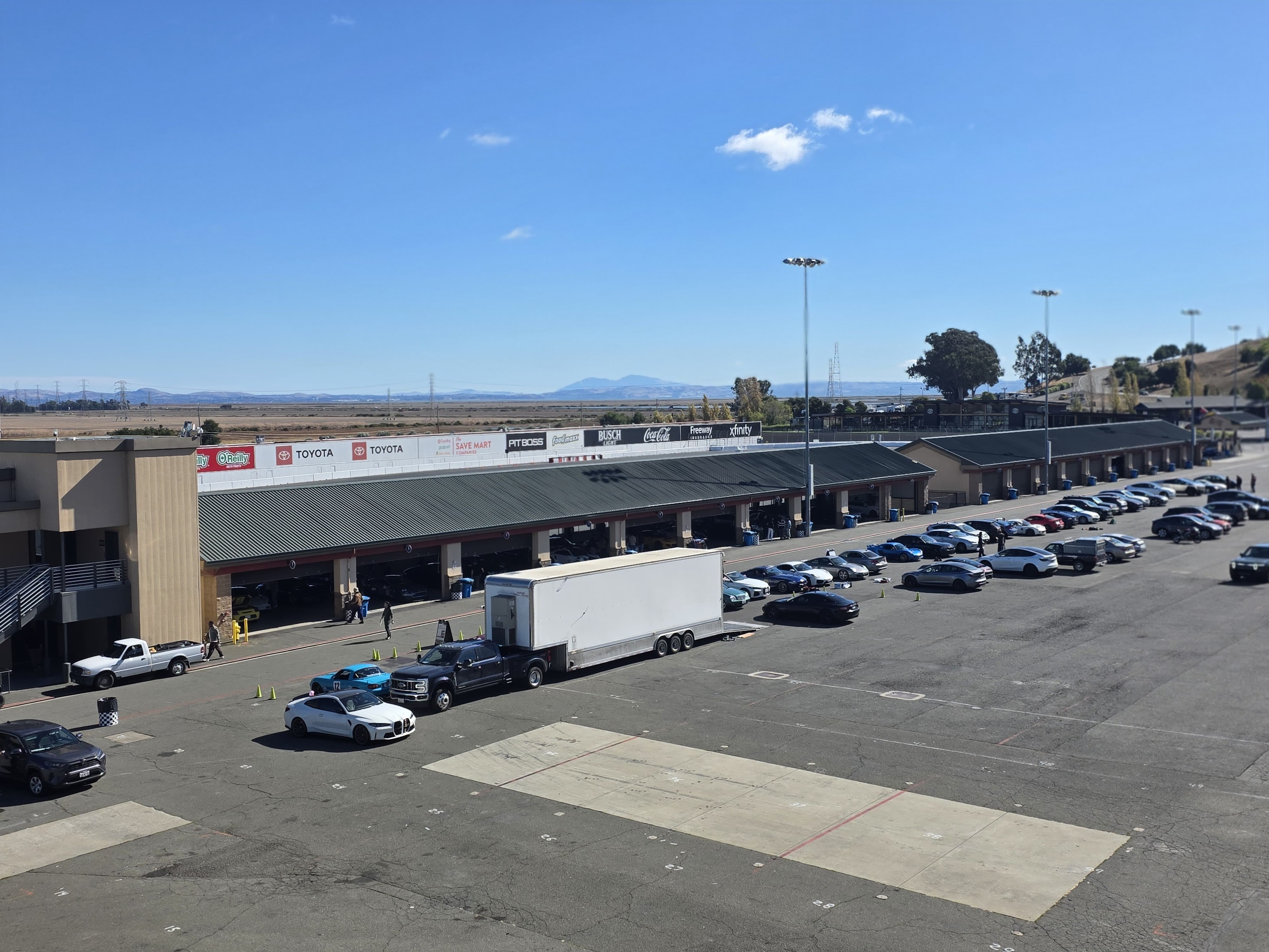 Elevated view of garage buildings and parked cars beside the circuit